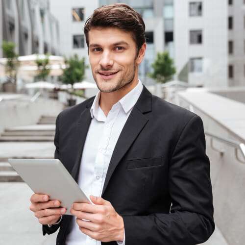 attractive young businessman using tablet near bus P52ZFZH villa,luxury villa